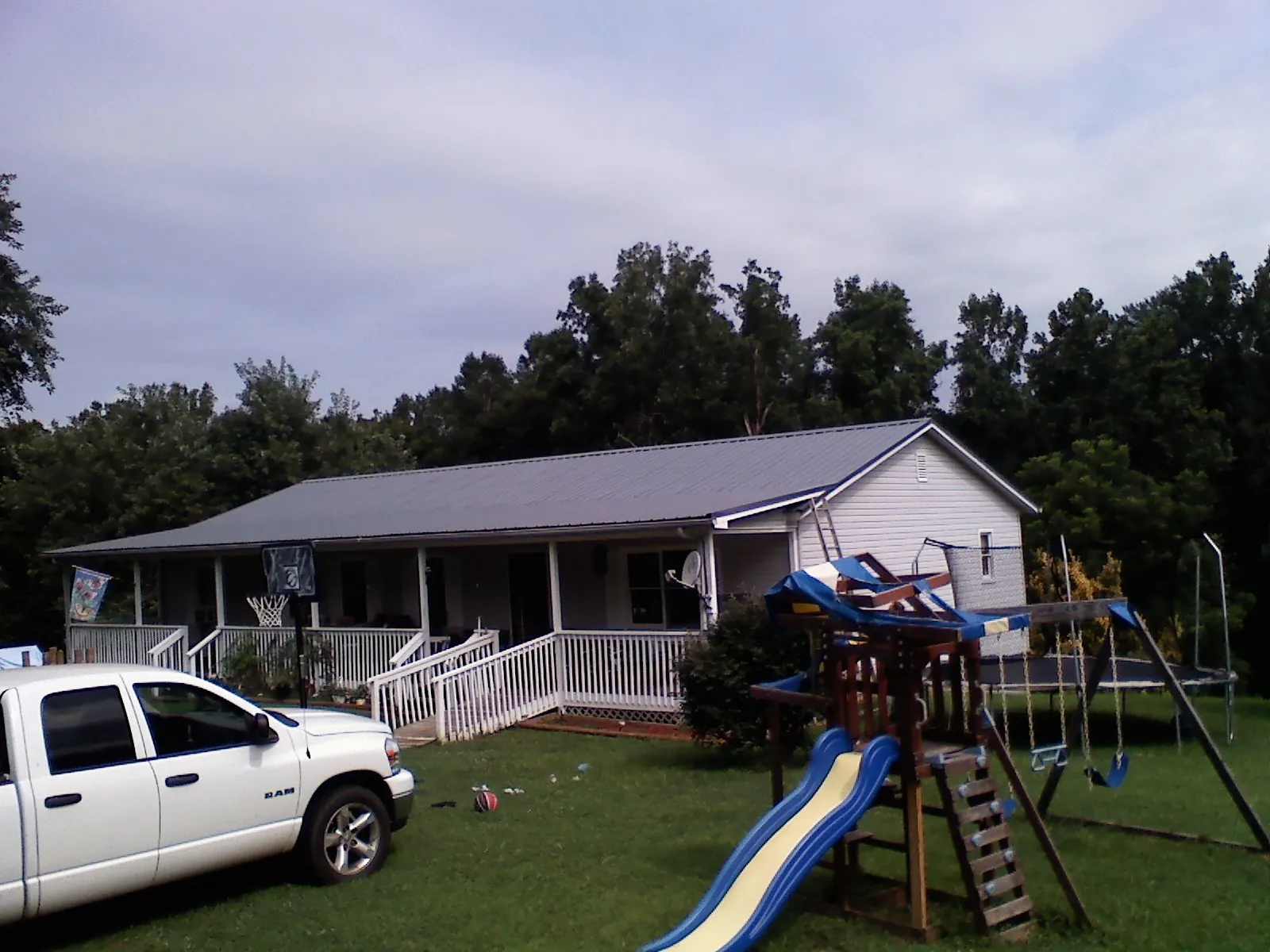 Dark metal roof on a country home with a full length front porch in Auburndale